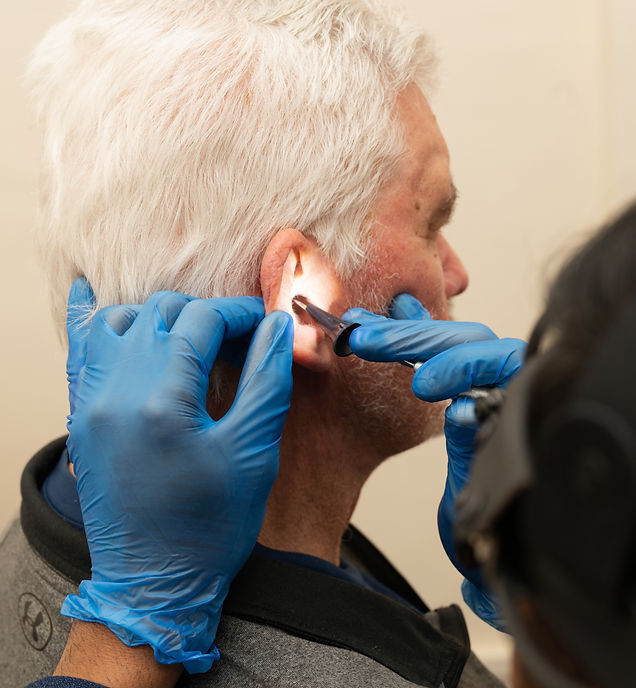 Audiologist carrying out ear wax removal